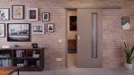 Front-Milieuansicht von der vor der Wand laufenden Schiebetür Taupe RAL 7048 Lack LA 24 bandseitig Basic - Huga
