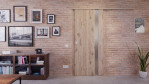 Front-Milieuansicht der vor der Wand laufenden HÖRMANN Schiebetür Pure 1 Nordeiche Duradecor DesignLine mit Lichtausschnitt Bandseite