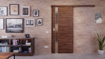Front-Milieuansicht der vor der Wand laufenden HÖRMANN Schiebetür Pure 1 Alpineiche quer Duradecor DesignLine mit Lichtausschnitt Schlossseite