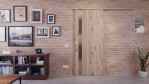 Front-Milieuansicht der vor der Wand laufenden HÖRMANN Schiebetür Pure 1 Nordeiche Duradecor DesignLine mit Lichtausschnitt Schlossseite
