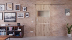 Front-Milieuansicht der vor der Wand laufenden HÖRMANN Schiebetür Pure 2 Nordeiche Duradecor DesignLine mit Lichtausschnitt quer mit bündiger Lisene Steel 79-7