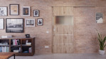 Front-Milieuansicht der vor der Wand laufenden HÖRMANN Schiebetür Pure 2 Nordeiche Duradecor DesignLine mit Lichtausschnitt quer mit bündiger Lisene Steel 80-7