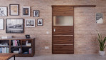 Front-Milieuansicht der vor der Wand laufenden HÖRMANN Schiebetür Pure 2 Alpineiche quer Duradecor DesignLine mit Lichtausschnitt quer mit Lisene Steel 80