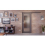 Front-Milieuansicht der vor der Wand laufenden HÖRMANN Schiebetür Groove 16 Staubgrau RAL 7037 Lack DesignLine mit Lichtausschnitt LA 27
